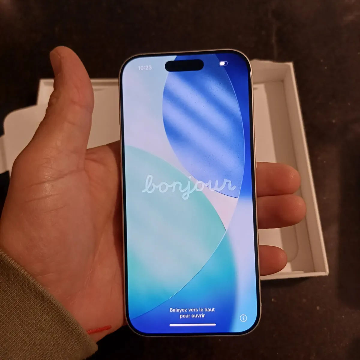 Cliente segurando o iPhone 17 Pro ligado na tela inicial
