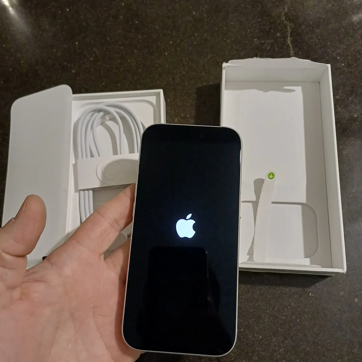 iPhone 17 Pro iniciando ao lado da caixa aberta com o cabo USB-C