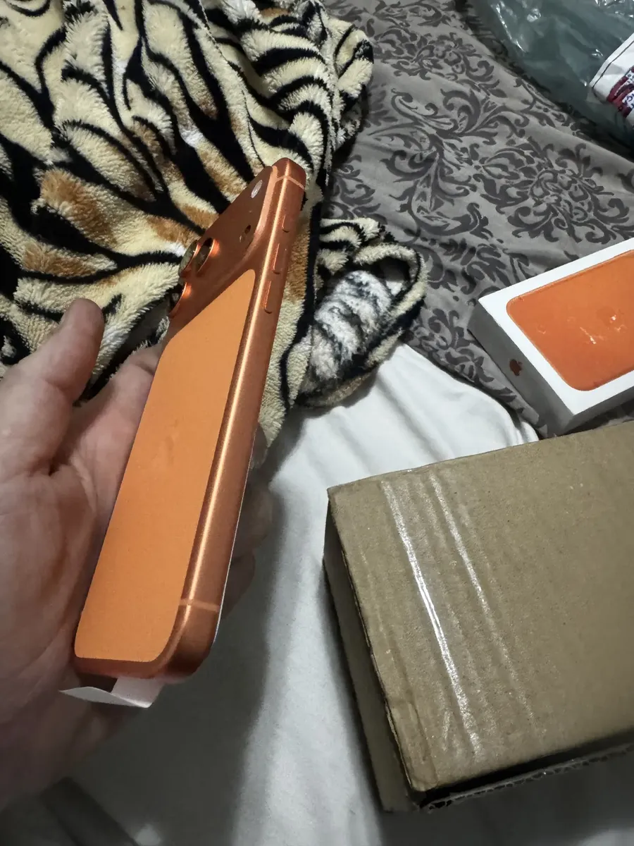 Laterais do iPhone 17 Pro Max laranja ao lado da embalagem de envio