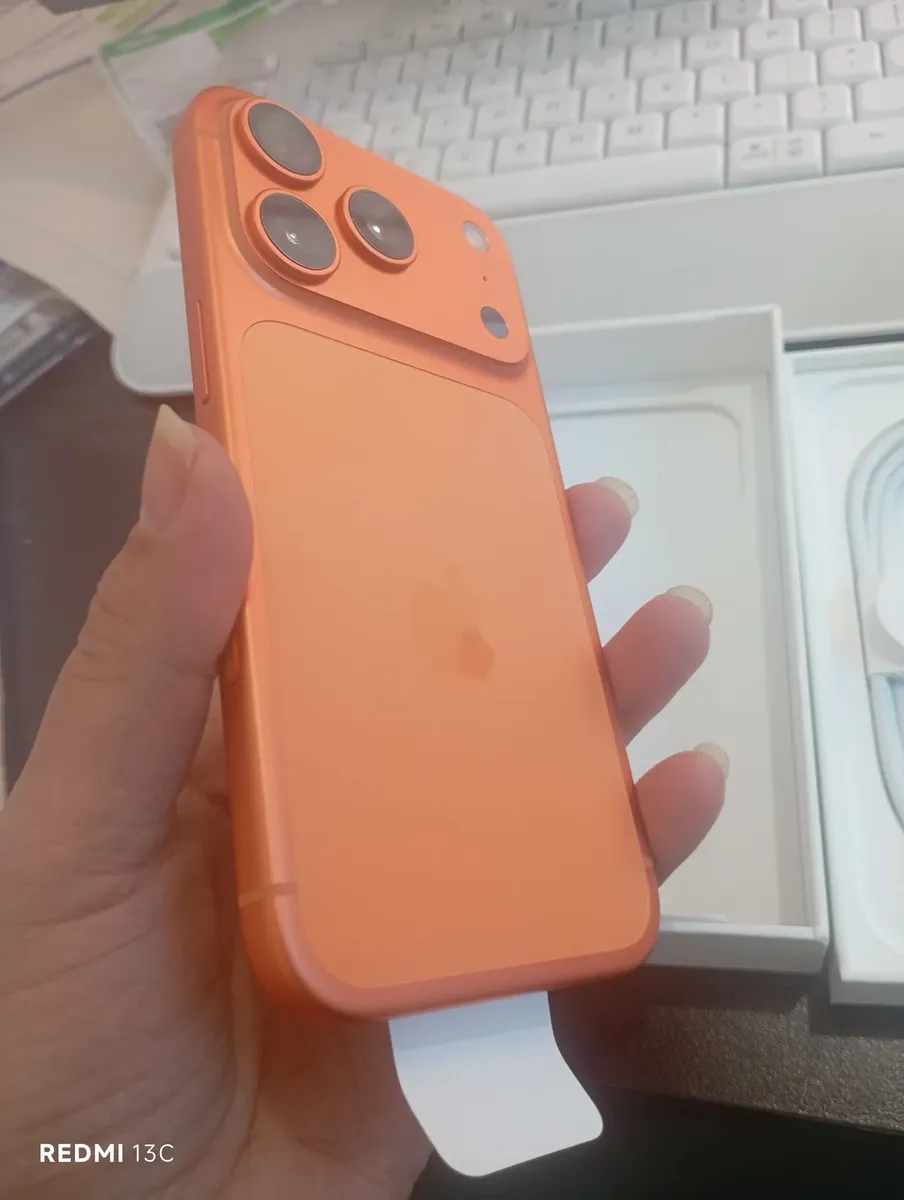 Traseira do iPhone 17 Pro Max Laranja Cósmico na mão do cliente